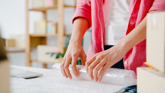 Young Asia entrepreneur businesswoman packing product in cardboa Folia bąbelkowa